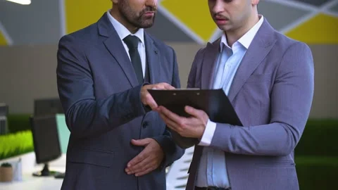 Close-up of men in the office discuss work issues, review documents Stock Footage 233717042