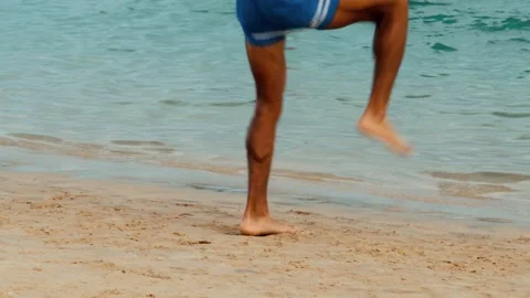 Close-up of men's athletic legs on a sandy beach doing physical exercises. Stock Footage 323739724