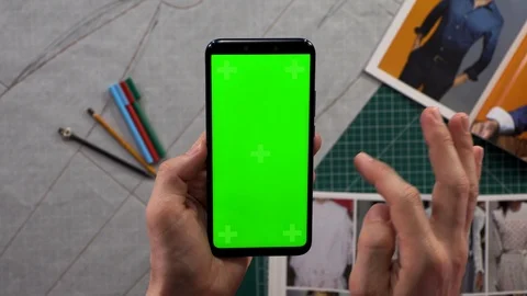 Close-up of men's hands holding smart phone vertical green screen in the backgro Vídeos de archivo 103285372