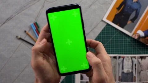 Close-up of men's hands holding smart phone vertical green screen in the backgro Stockbeeldmateriaal 103285698