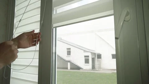 Close-up of men's hands lifting roller blinds on the window in a chain Video stock 240132971