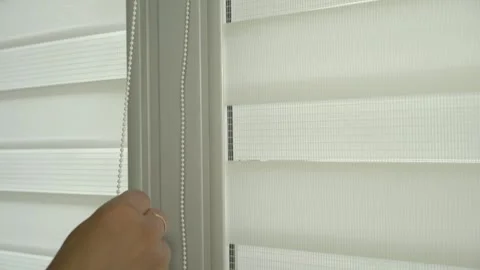 Close-up of men's hands lifting roller blinds on the window in a chain Stock-Footage 247833508
