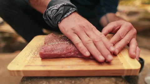 Close-up of men's hands rubbing spices into meat Stock Footage 256420983