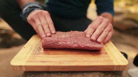 Close-up of men's hands rubbing spices into meat Stock Footage 256421117