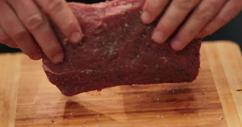 Close-up of men's hands rubbing spices into meat Stock Footage 256422844