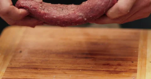 Close-up of men's hands rubbing spices into meat Stock Footage 256426436