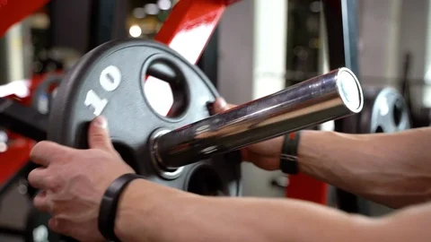 Close-up of men's hands setting the weight before training in the gym Stock Footage 108635208