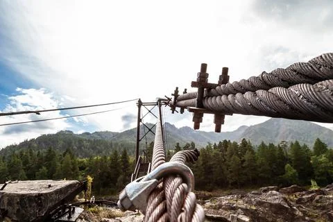 Close-up on a metal binding cable going in perspective to the bridge support  Stock Photos