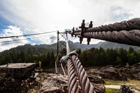 Close-up on a metal binding cable going in perspective to the bridge support  Stock Photos