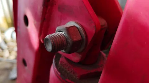 Close-Up of a Metal Bolt on a Red Mechanical Structure in Detail Stock Footage 311513619