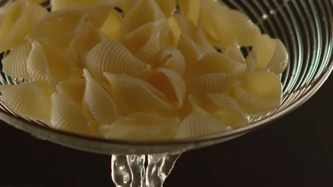 Close-up of metal colander with cooked pasta dripping water. Slow motion video Stock Footage 116102236
