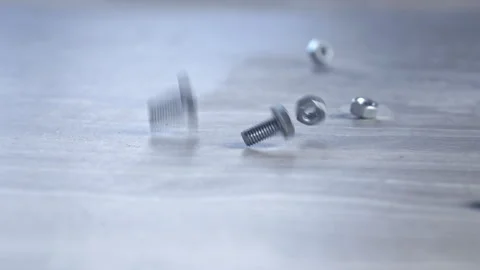 Close-up. Metal fastening bolts and nuts fall on a gray metal surface Stock Footage 248711953