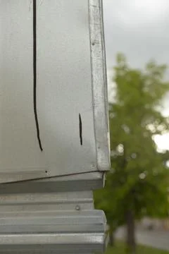 Close-up of Metal Gutter Corner with Tree Background Stock Photos