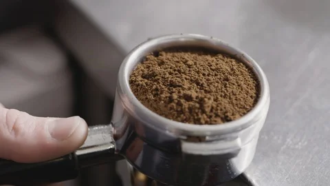 Close-up in the metal holder of the coffee machine, the barista hands press the Stock Footage 129638045