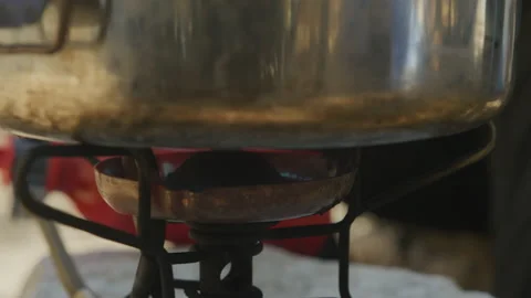Close up of metal pot sitting on backpacking camp stove at camp site Stock Footage 221740994