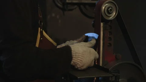 Close-up of metal sharpening. Blacksmith finishes work Stock Footage 143462190