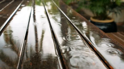 Close-up of a metal sheet, on which raindrops drip, leaving circles on the water Stock Footage 104924764