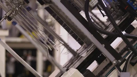 Close up on metal spring coils being fed through automated machinery Stock Footage 85187991