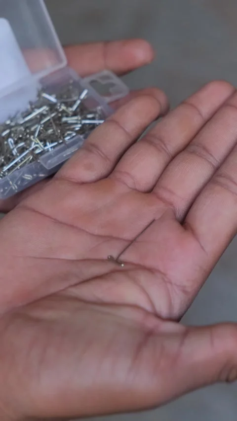 Close up of a metal T-pin held in an open palm 库存影片 332655707