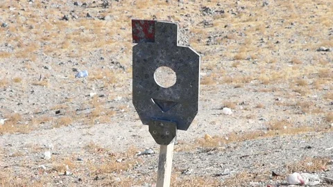 Close up of a metal target being fired upon in the desert. 24fps Stock Footage 121941810