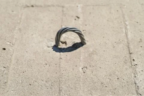 Close-up of a metal wire loop embedded in a concrete surface Stock Photos