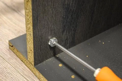 Close Up of Metallic Cam Lock Nut Installed in Furniture Panel 库存照片