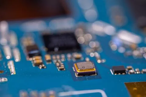 Close up of metallic microchip mounted on blue electronic circuit board wit.. Stock-Fotos