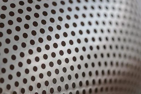 Close-up on a metallic perforated surface or metal grate with uniformly sized Stock Photos