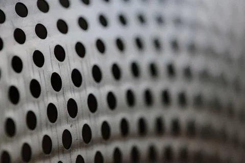 Close-up on a metallic perforated surface or metal grate with uniformly sized Stock Photos