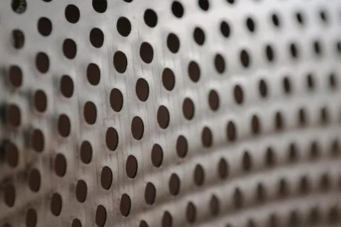 Close-up on a metallic perforated surface or metal grate with uniformly sized Stock Photos