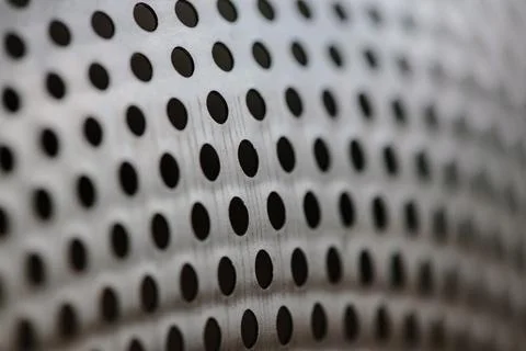 Close-up on a metallic perforated surface or metal grate with uniformly sized Stock Photos