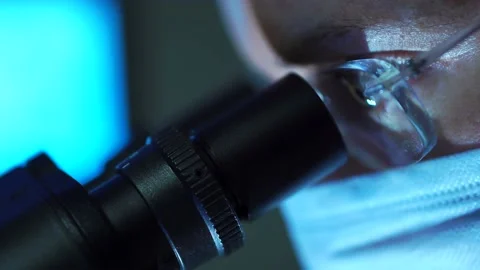 Close Up Of Microbiologist Looking Through A Microscope Stock Footage 131074038