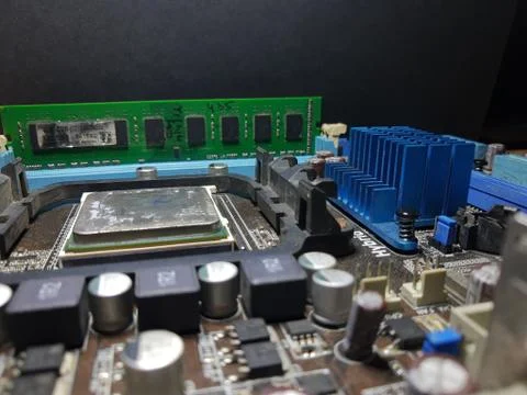 A close-up microchip with many electrical components placed on the Motherboard Stock Photos