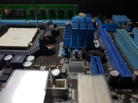 A close-up microchip with many electrical components placed on the Motherboard Stock Photos