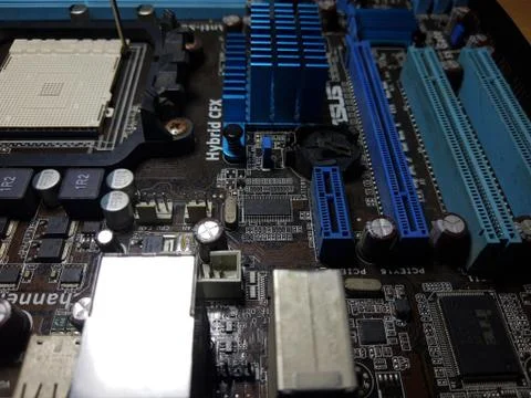 A close-up microchip with many electrical components placed on the Motherboard Stock Photos
