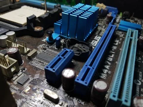 A close-up microchip with many electrical components placed on the Motherboard Stock Photos