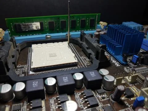 A close-up microchip with many electrical components placed on the Motherboard Stock Photos