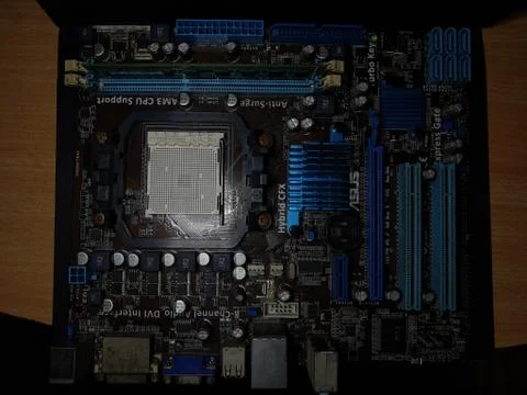 A close-up microchip with many electrical components placed on the Motherboard Stock Photos