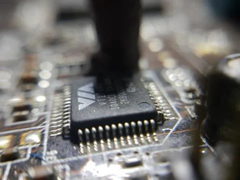 A close-up microchip with many electrical components placed on the Motherboard Stock Photos