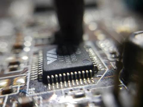 A close-up microchip with many electrical components placed on the Motherboard Foto stock