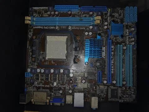 A close-up microchip with many electrical components placed on the Motherboard Stock Photos