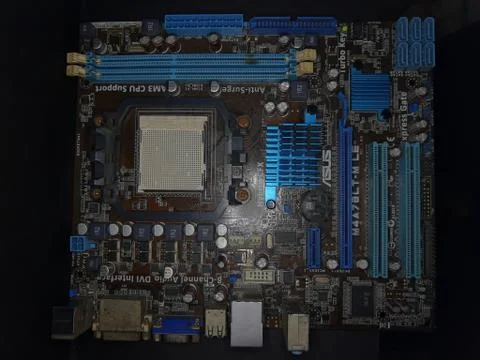 A close-up microchip with many electrical components placed on the Motherboard Stock Photos