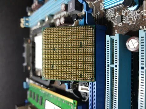 A close-up microchip with many electrical components placed on the Motherboard Stock Photos