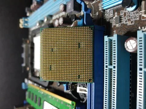 A close-up microchip with many electrical components placed on the Motherboard Stock Photos