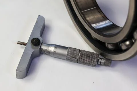 Close-up of a micrometer depth gauge and steel ball bearing isolate on white. Stock Photos