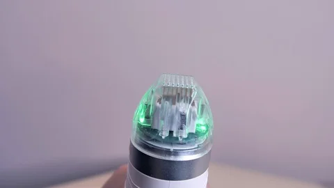 Close-up. Microneedle RF lifting device slightly rotating in a doctor's hand on Stock Footage 120627922