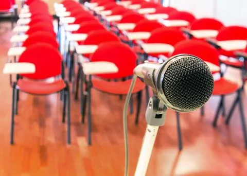 Close up of microphone in front of empty chairs in conference room Stock Photos