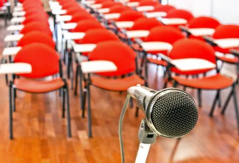 Close up of microphone in front of empty chairs Stock Photos