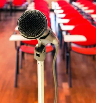 Close up of microphone in front of empty chairs in conference room Stock Photos