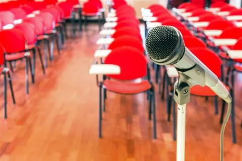 Close up of microphone in front of empty chairs Stock Photos